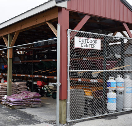 Lawn & GardenOutdoor center with a red-roofed open structure, displaying garden tools, lawnmowers, propane tanks, and soil bags, creating a practical, rustic vibe.